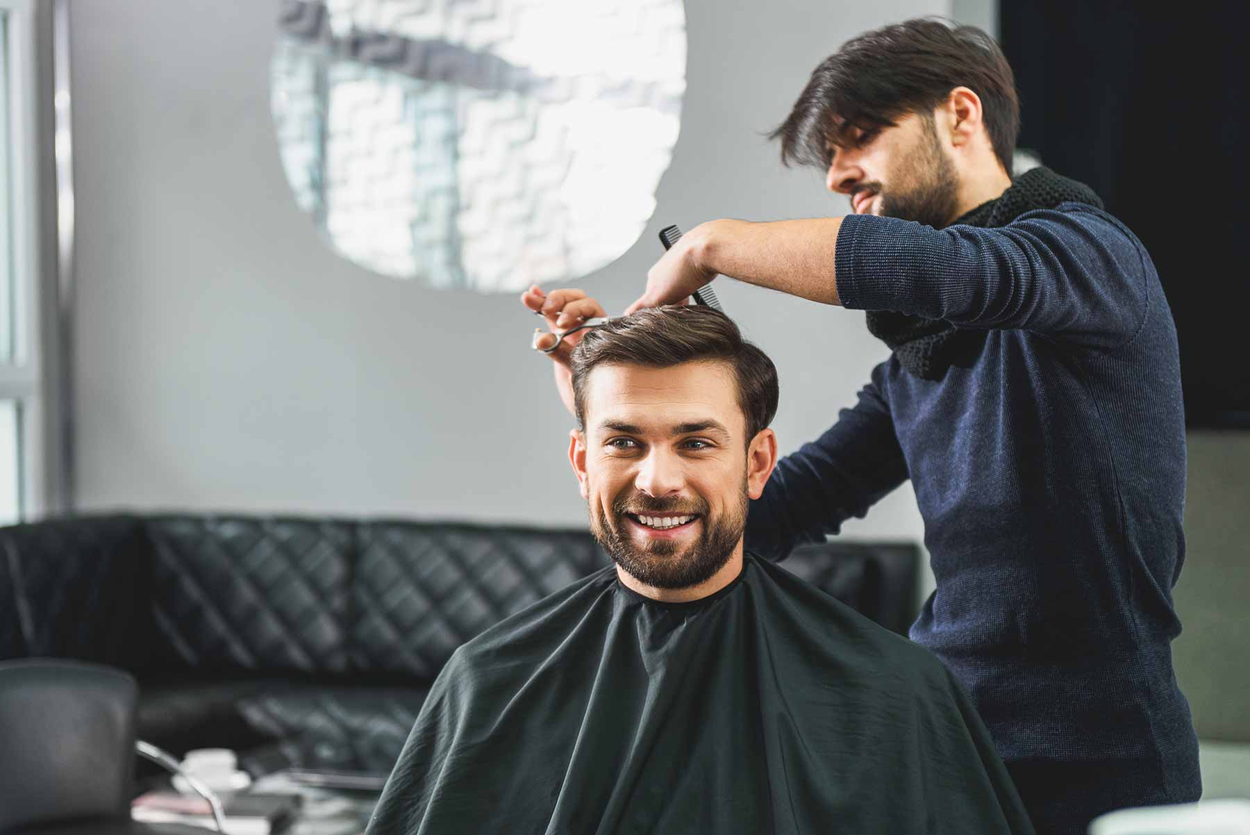 A smiling client getting a professional haircut in a barber shop