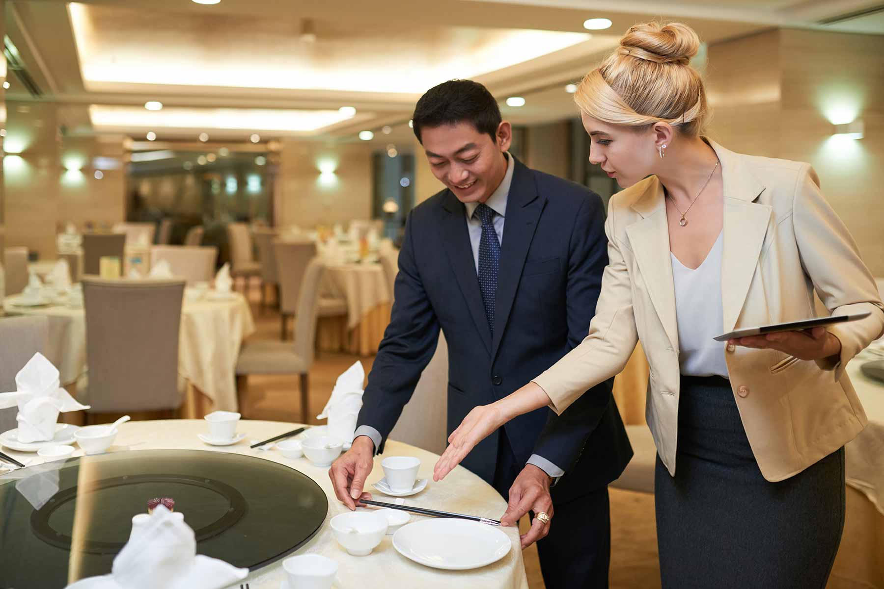 Event planner and banquet manager discussing table setting Event planner and banquet manager discussing table setting